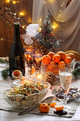 Fototapeta na wymiar Traditional Russian Christmas Salad Olivier with champagne and tangerines