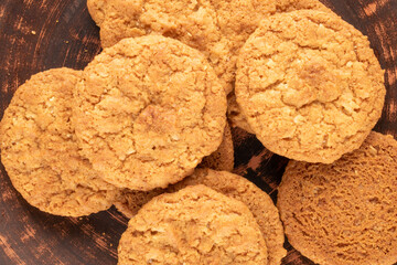 Several sweet homemade cookies on a clay dish, macro, top view.