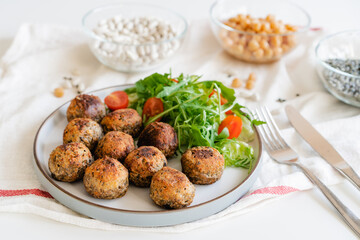 Vegan veggie meatballs on the plate with fresh salad. Plant based pea protein ingredients on the...