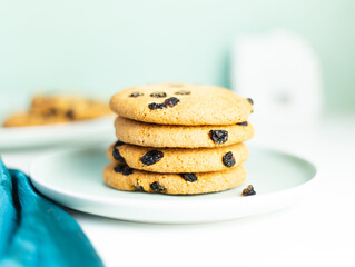 A stack of Giant cookies with raisins lies on a light green plate.
