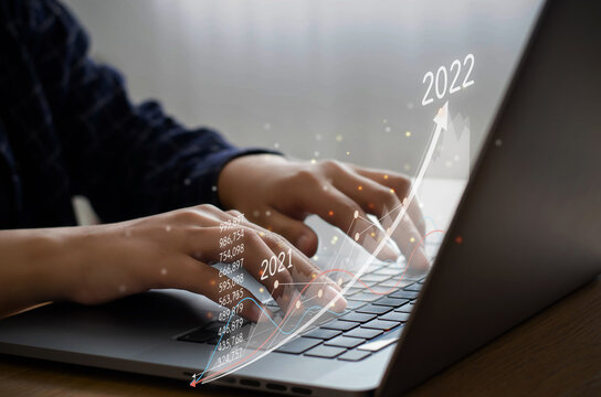 Businessmen are typing computers to plan their business and financial growth. the increase in the graph That indicates positive growth in 2022 to increase business growth and increase business growth.