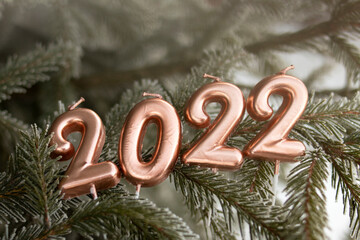 Green spruce branch. candles numbers 2022. New Years concept of welcoming New Year 2022, candles of...