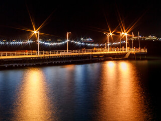 Fototapeta na wymiar Illuminated sea pier at night 