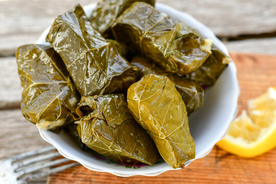 Dolmades - stuffed grape leaves  rolls  with rice the Greek way on wooden table .Stuffed greek wine leaves