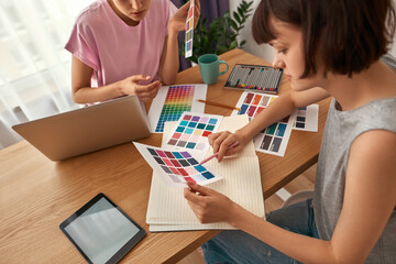Young female designers choosing color in palette