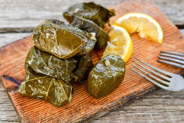 Dolmades - stuffed grape leaves  rolls  with rice the Greek way on wooden table .Stuffed greek wine leaves