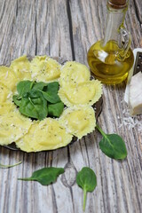 Italian pasta for ravioli with spinach and ricotta on rustic wood background. Vertical