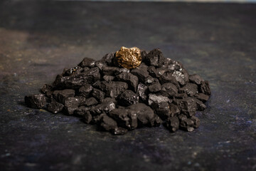 hard coal in the pile. a piece of gold among the coal. extracted underground.