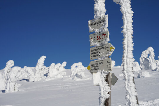 Touristic signs on pole in winter covered with snow, Krkonose Giant Mountains winter landscape hiking, Czech Republic