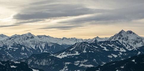 Naklejka na ściany i meble Wolkenstimmung im Dezember über den Gipfeln der Salzburger Bergwelt, im Hintergrund die hohen Tauern.