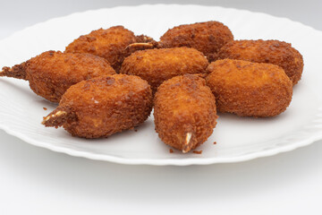 Thighs of the Sea or Thighs of Crabs, (Muslitos de Mar o Muslitos de Cangrejo). Spanish food, tasty and crunchy. Fried in plenty of hot oil. Isolated on white background. Selective focus.