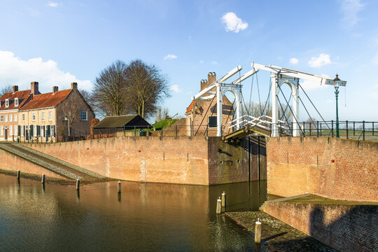 View of the white old drawbridge in the harbor of the city of Heusden surrounded by its fortified walls.