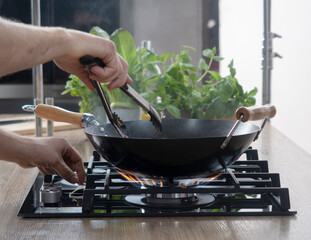 Frying pan on a gas stove. Chef controls the cooking process. cooking on a gas stove. expensive gas in Europe. 