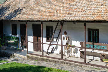 Fototapeta na wymiar Old rural house and courtyard with benches, stairs in village of Holloko in Hungary