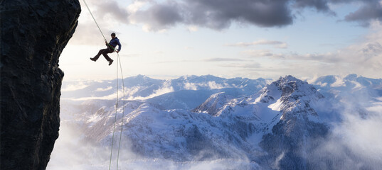 Adult adventurous man rappelling down a rocky cliff. Extreme adventure composite. 3d rendering mountain artwork. Aerial background landscape from British Columbia, Canada.