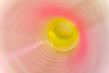Pink and yellow slinky walking spring toy detail, pastel plastic spiral abstract background