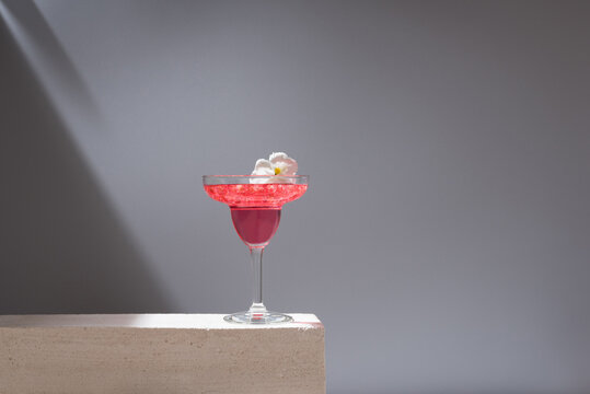 Glass of pomegranate margarita with flower blooms