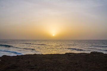 Coucher de soleil devant un falaise