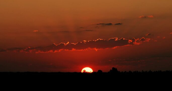 Beautiful time lapse of an orange sunrise in a huge field