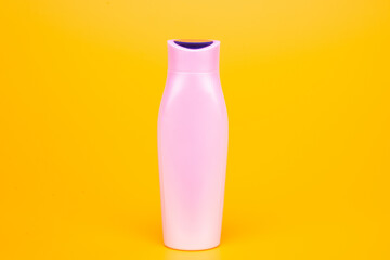 white shampoo bottle on yellow background, skincare