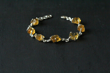 Citrine bracelet. Bracelet made of stones on hand from natural stone Citrine. Bracelet made of natural stones. Handmade jewelry. Handmade bracelets on black modern background. Stylish stone jewelry