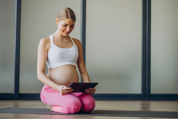 Pregnant woman exercicising on a class of pilates