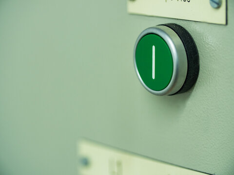 Green push button on a switchboard to control electricity power for an apartment building. 