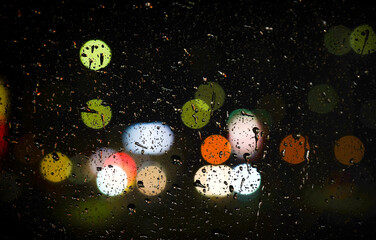 background of glowing lights through raindrops