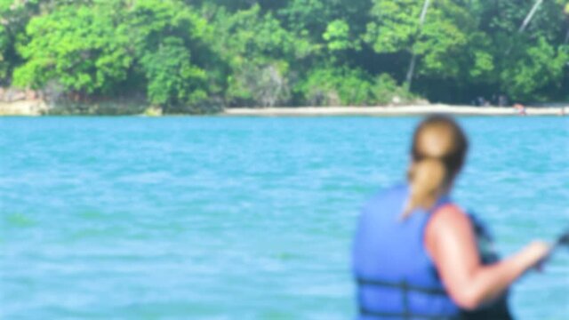 BLURRED background of a woman passing in front of the screen paddling on a river. Concept of water sport background for text.