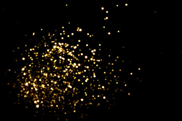 Golden blurred bokeh lights on black background. Glitter sparkle stars for celebrate. Overlay for your design