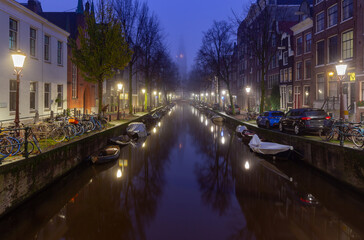 Fototapeta premium Beautiful old houses on the city waterfront of Amsterdam at sunset.
