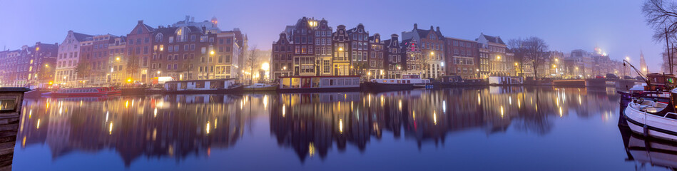 Fototapeta na wymiar Panorama of the city waterfront of Amsterdam on a foggy morning.