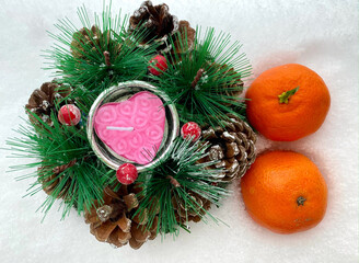 Fototapeta na wymiar New Year's decorative ornament on snow. Tangerines on white. Ekiban decorations with candles