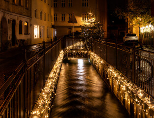 Fototapeta na wymiar Canal in Augsburg decoreated with chrismas lights