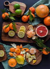 Frische Orangen auf schwarzem Hintergrund, Auswahl Orange, Mandarine, Zitrone, Limette,...