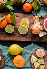 Frische Orangen auf schwarzem Hintergrund, Auswahl Orange, Mandarine, Zitrone, Limette,...