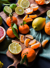 Frische Orangen auf schwarzem Hintergrund, Auswahl Orange, Mandarine, Zitrone, Limette, geschnittene und halbierte Früchte