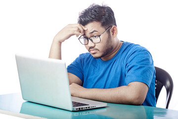 casual dressed boy stressed expression in front of a laptop