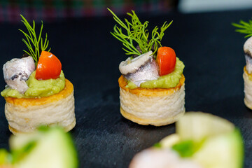 Tartlet with guacamole, anchovies, tomato, olive and dill. Special celebration meal