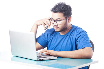 young man using laptop and talking over cell phone