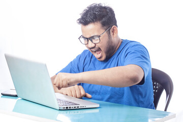 frustrated man screaming and punching his laptop screen