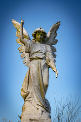 Cemetery angel against blue sky.