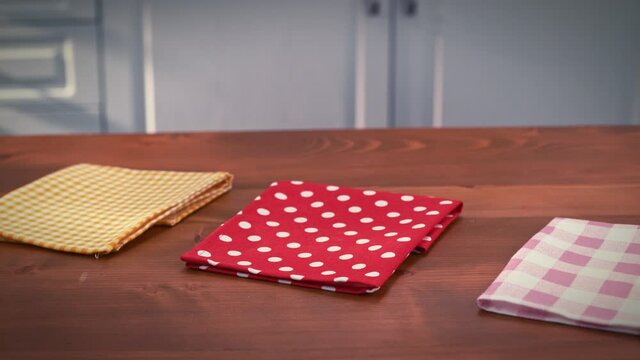 Colorful cloth napkins on a wooden floor in the kitchen. The camera is spinning. Creative people can put whatever they want on the napkin.