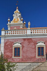 Fototapeta na wymiar NeoRococo palace-pink facade-stairway with iron railing-clock tower-white balustrade-rooftop statues. Estoi-Algarve-Portugal-032