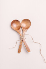 Two wooden spoons on light background. Spoons for soup, salad or porridge. Eco friendly kitchen utensils. Table setting