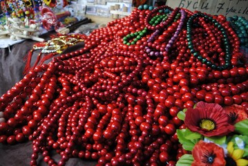 
Background from red natural stone beads of ruby ​​color. Red bead necklaces. Crafts, handicrafts, jewelry making