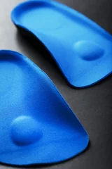 Foto auf Acrylglas Orthopedic insoles for correction of the blue color of the foot on a black background. © Alexander