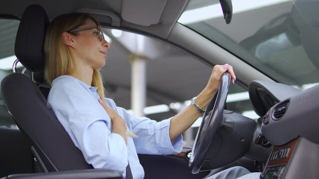 Elegant blond woman in stylish shirt and eyeglasses coughing sitting on driver seat in her car, cannot cure obsessive cough, coronavirus or bronchitis consequences, smoking effect
