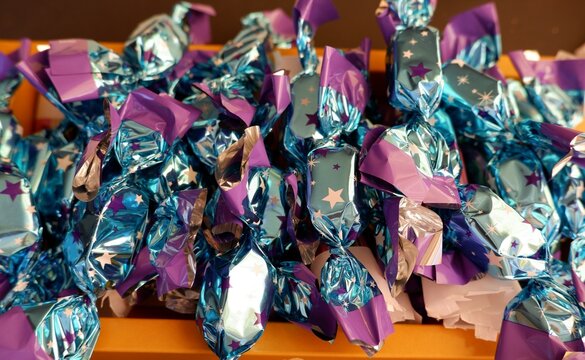 traditional Hungarian Christmas sweets in bright colorful ornate purple and blue colour packaging named szaloncukor in yellow paper box