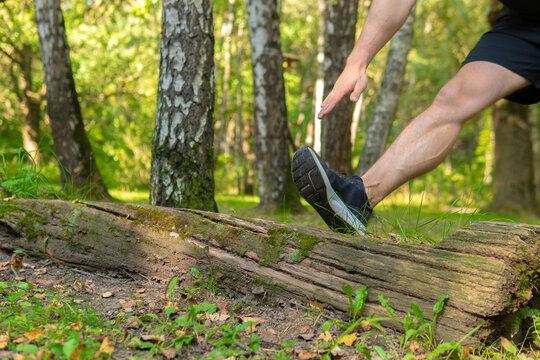 A young enduring athletic athlete is doing stretching in the forest outdoors, around the forest, oak trees.active forest, fitness young recreation motion, jogging wellbeing. Summer leisure runners